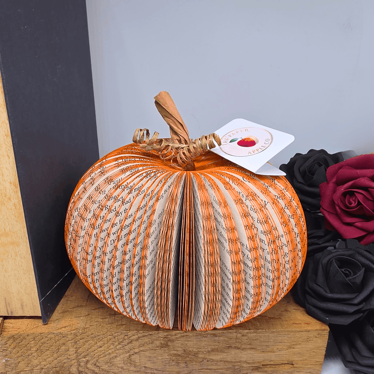 Medium handmade book pumpkin displayed with autumn floral decor
