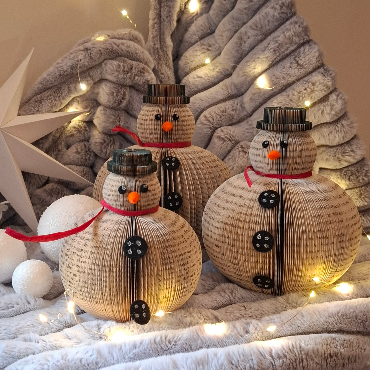 Set of 3 book page snowmen ornaments displayed in seasonal setting