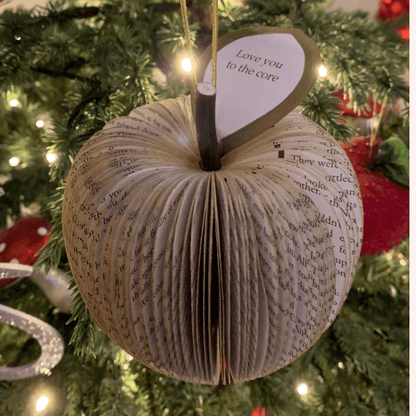 Close-up of hanging gold glitter apple showing hand-cut book pages detail