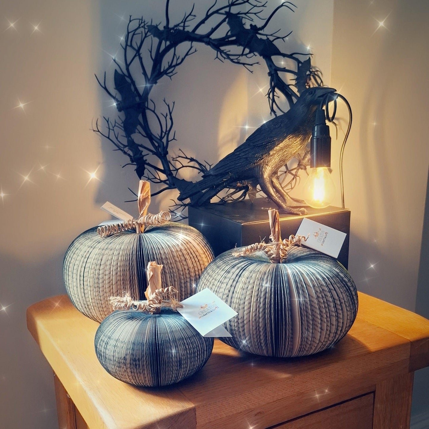 Set of 3 black handmade book pumpkin held in hands to show size