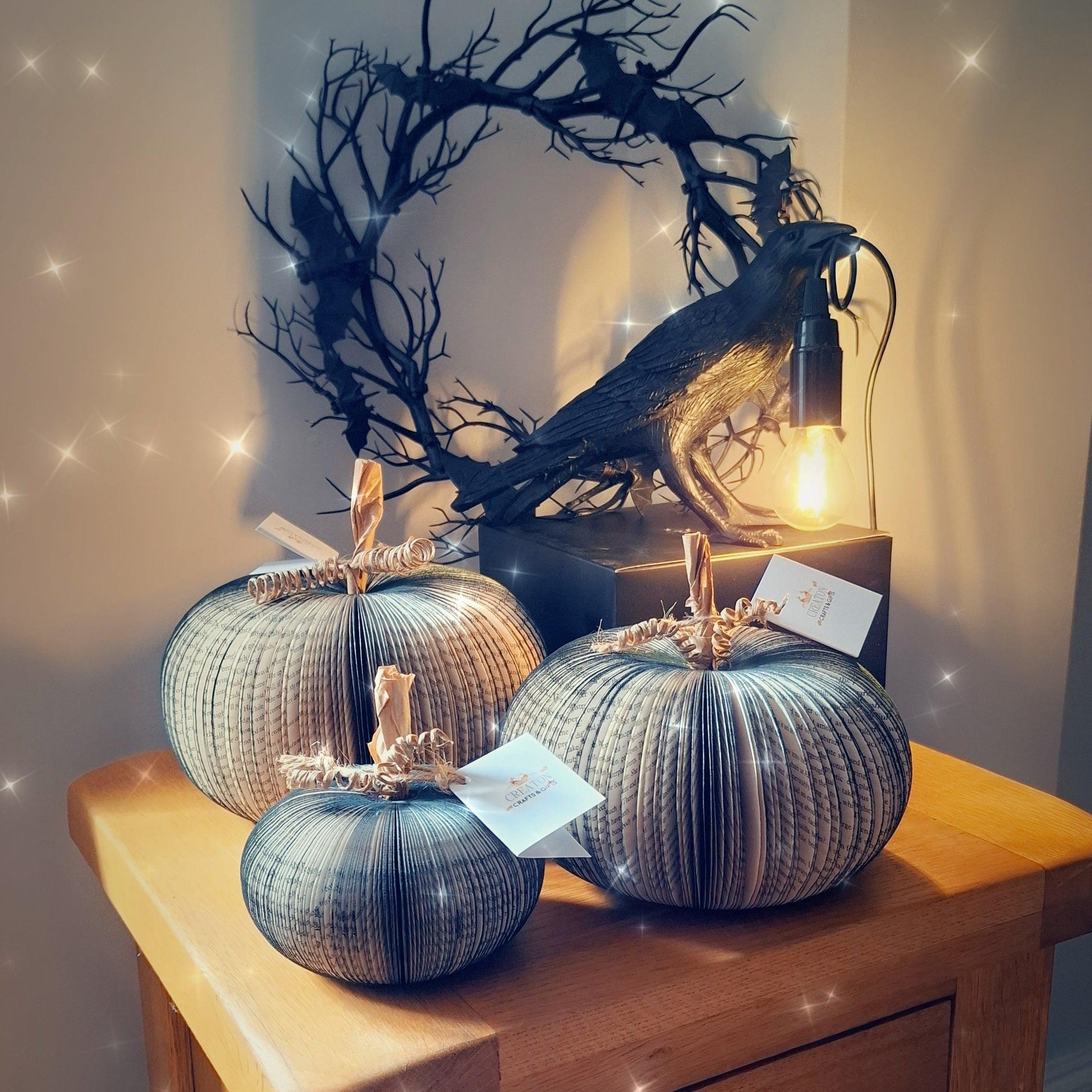 Set of 3 black handmade book pumpkin held in hands to show size