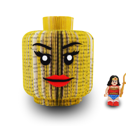 Side view of handmade block head book art female face design, hand-cut from real book pages, shown with toy figure for scale, figure not included
