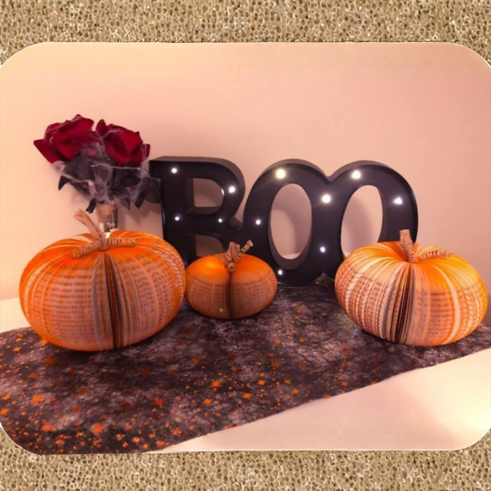 Book pumpkins displayed with a 'BOO' Halloween sign, handmade papercraft decoration