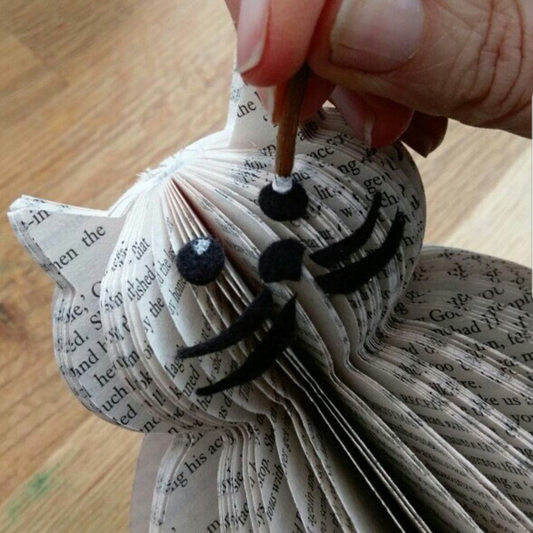 Close-up of hand cutting details on a handmade book page cat