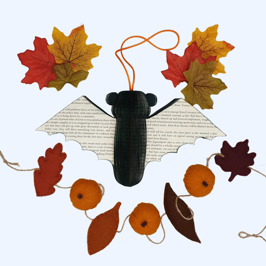 Handmade book bat Halloween decoration with autumn leaves and mini felt pumpkins