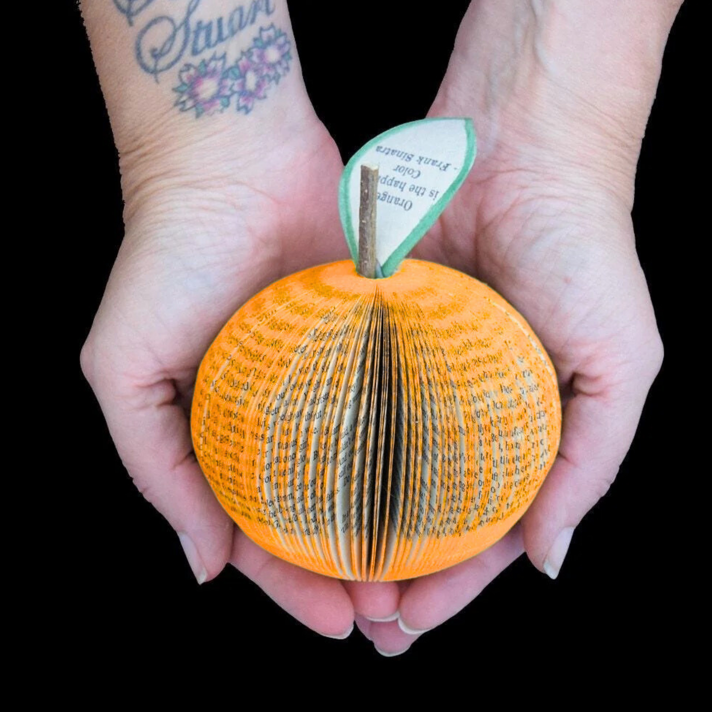 Handmade orange anniversary gift shown in hands to demonstrate size approximately 9cm