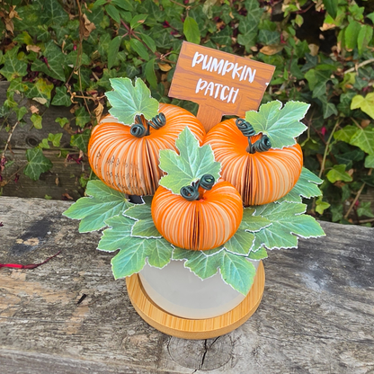 Close-up of Pumpkin Patch Pot outdoors, handmade book-page pumpkins with wired green stems and a wooden Pumpkin Patch sign