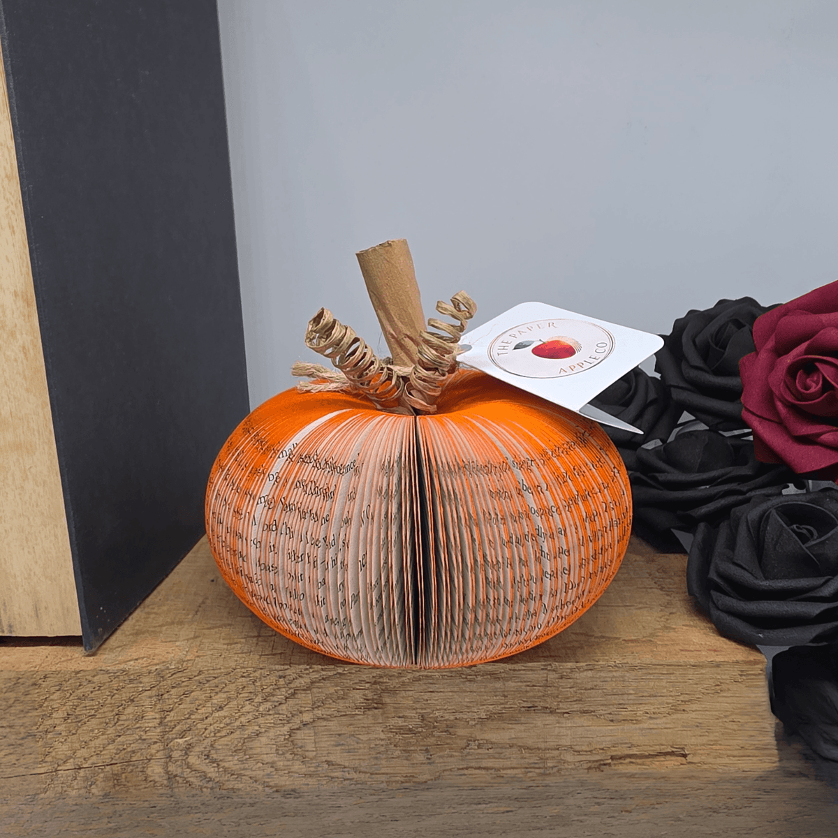 Small handmade book pumpkin displayed with autumn floral decor