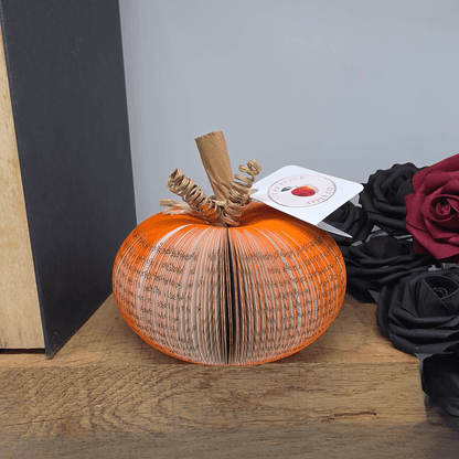 Small handmade book pumpkin displayed with autumn floral decor