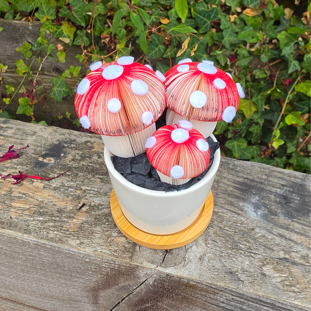 Toadstool Trio Pot from above, three red and white spotted paper toadstools in a white ceramic pot on a bamboo tray
