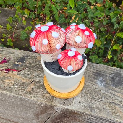 Toadstool Trio Pot from above, three red and white spotted paper toadstools in a white ceramic pot on a bamboo tray