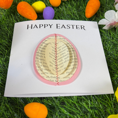 Handmade Easter card with a 3D egg made from book pages on a spring floral background