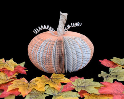 Medium book page pumpkin held in hands to show size