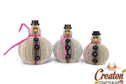 Set of 3 book page snowmen ornaments held in hands to show size