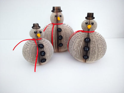 Individual pieces from set of 3 book page snowmen ornaments showing detail