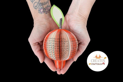 Handmade book pomegranate held in hands to show size