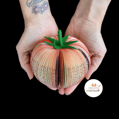 Handmade book tomato held in hands to show size