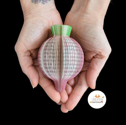 Handmade book page beetroot sculpture held in hands to show size