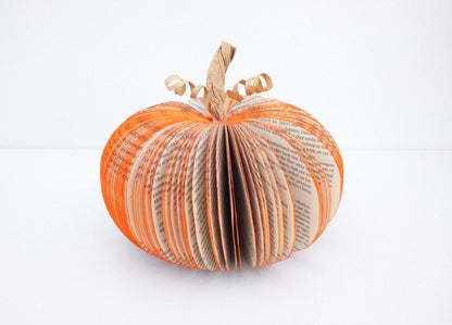 Large book page pumpkin held in hands to show size