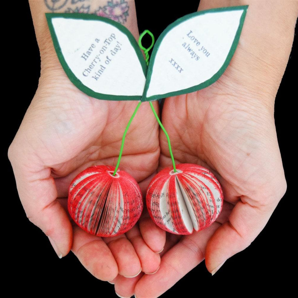 Handmade personalised paper cherries crafted from reclaimed book pages being held in hands, unique 4th wedding anniversary fruit gift.